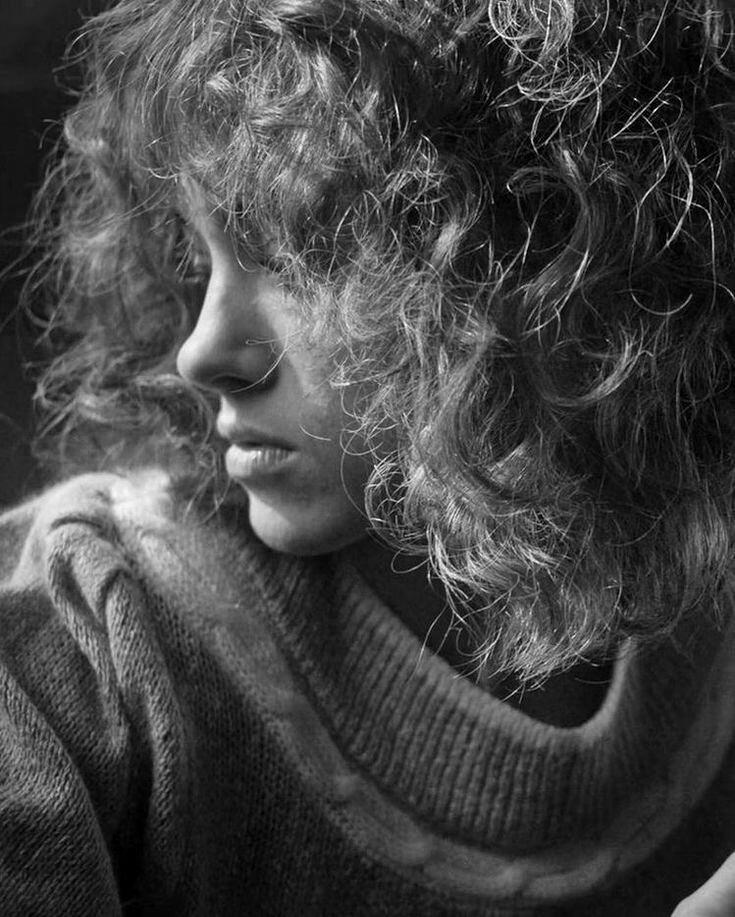 a black and white photo of nancy wheeler from stranger things looking left.