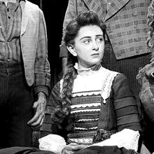 a black and white photo of winnie foster from tuck everlasting (2016) looking right.