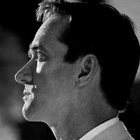 a black and white photo of tom wambsgans from succession looking left.