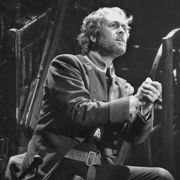 a black and white photo of jean valjean from les mis looking right.